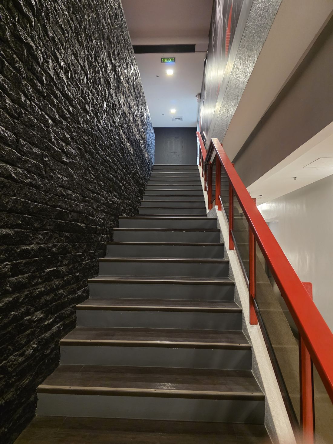 Stone staircase with red railing at Sideline Sports